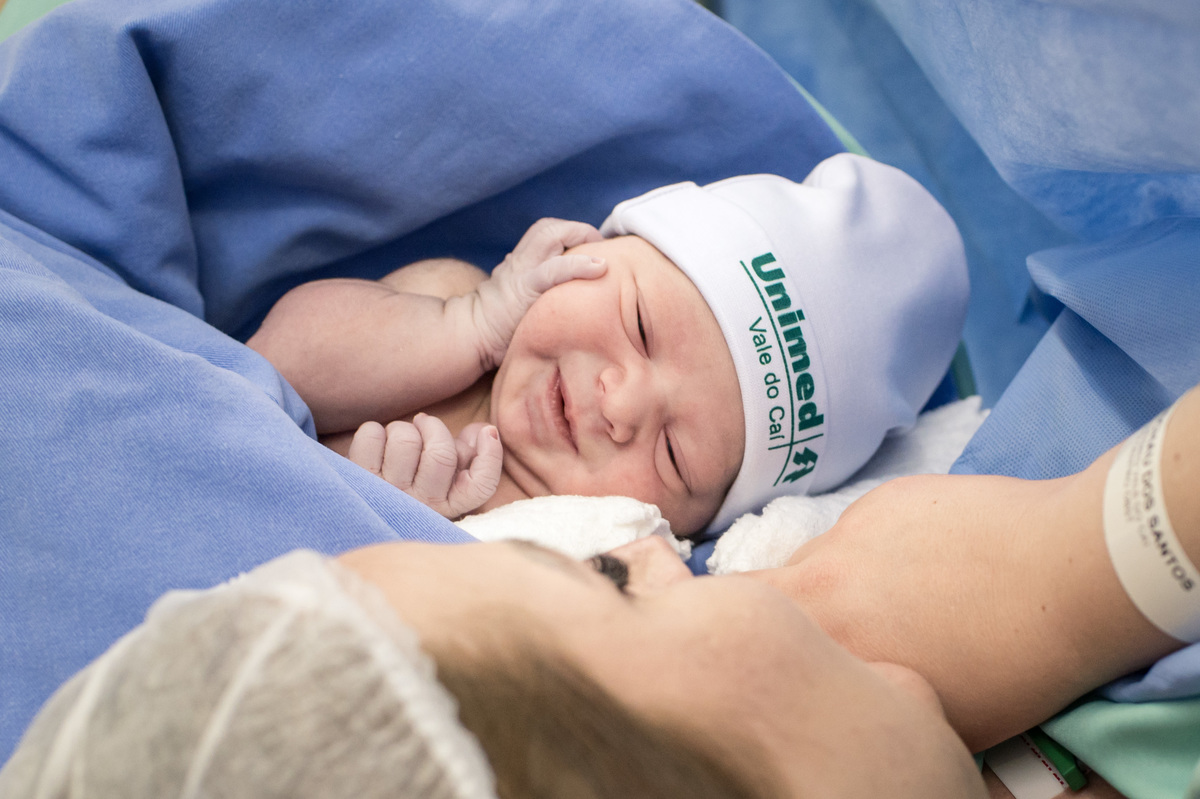 bebê recém nascido fazendo pose com as mãzinhas