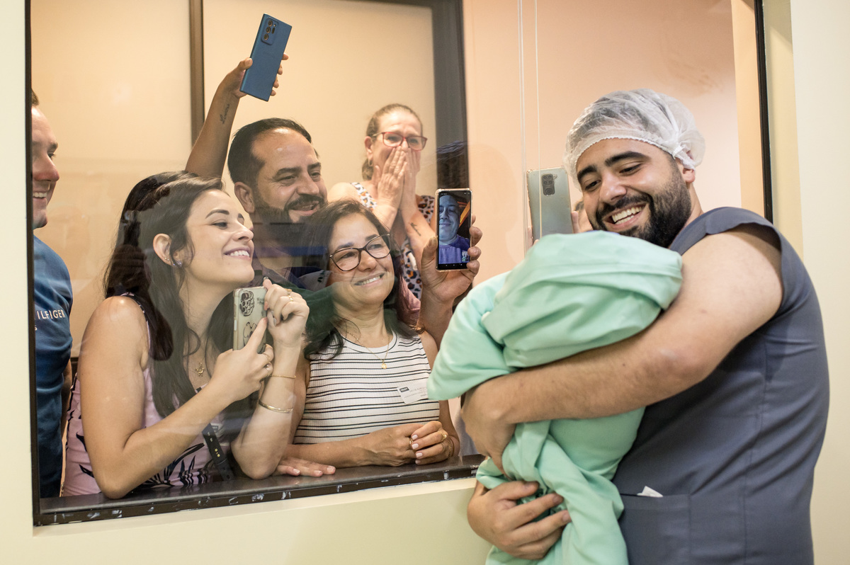 família vendo o bebê recém nascido pela primeira vez após o nascimento