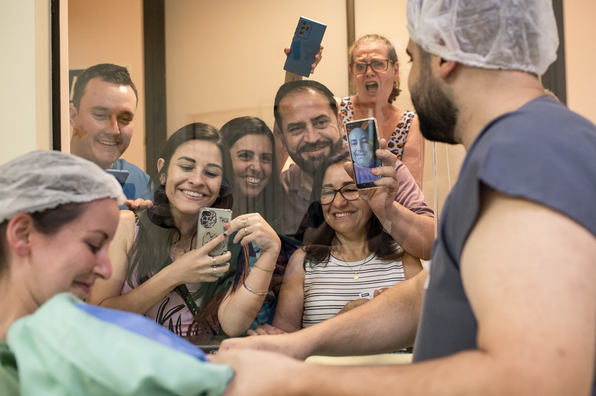 família vendo o bebê recém nascido pela primeira vez após o nascimento