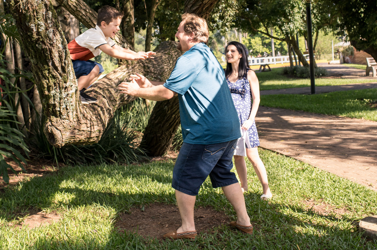 Ensaio de gestante, criança pulando no colo do pai