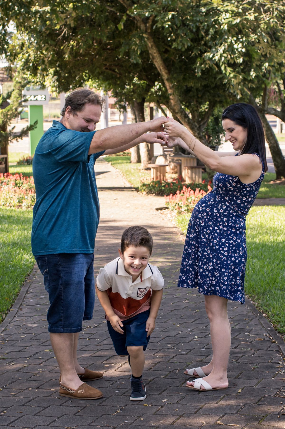 Ensaio de gestante, criança correndo no meio dos pais