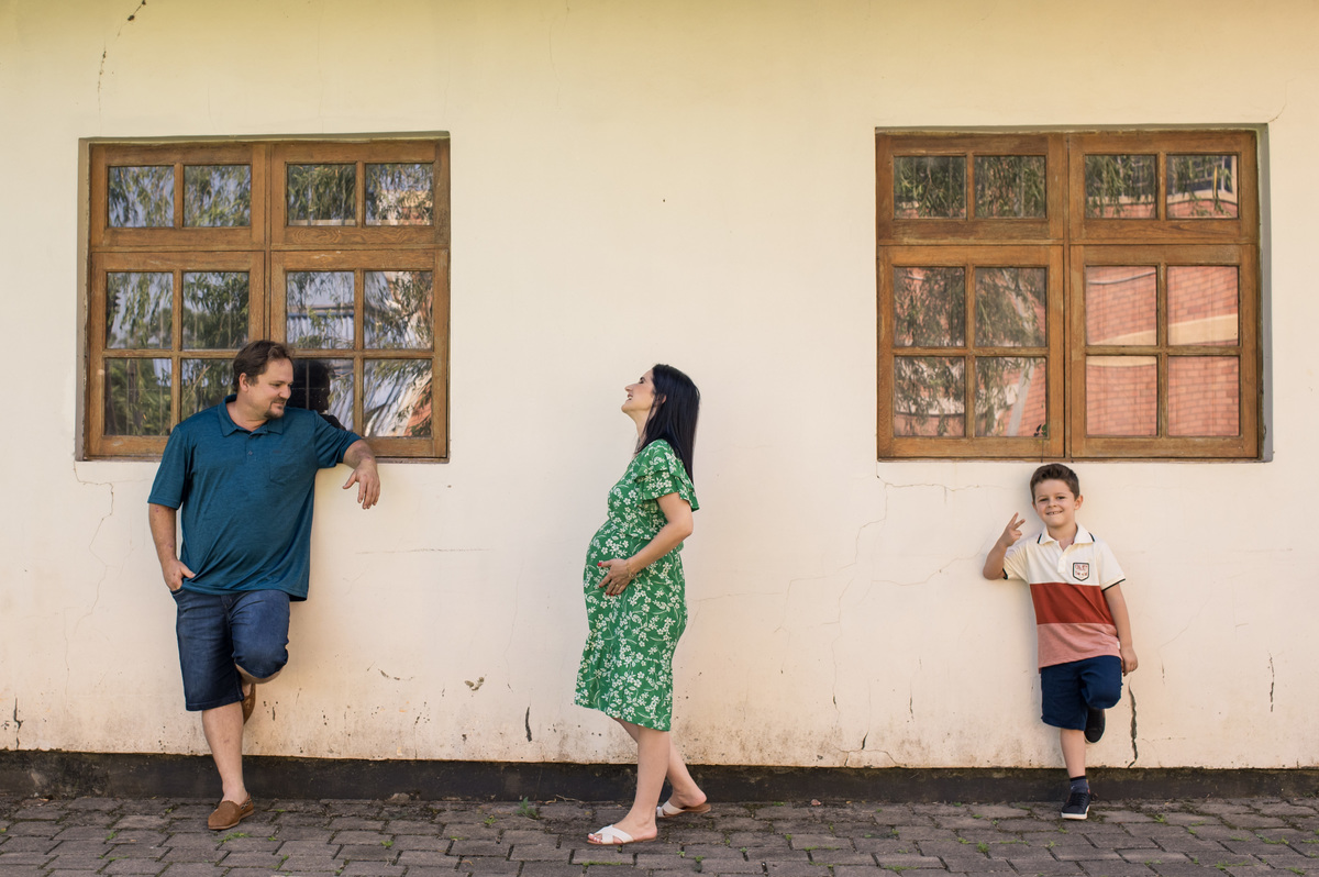 Ensaio de gestante, mamãe caminhando feliz, pai e irmão sorrindo
