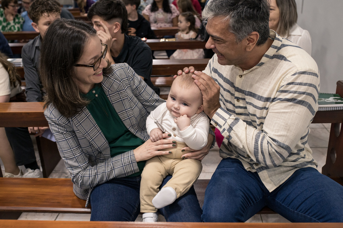 Foto de bebê no batizado no colo dos dindos