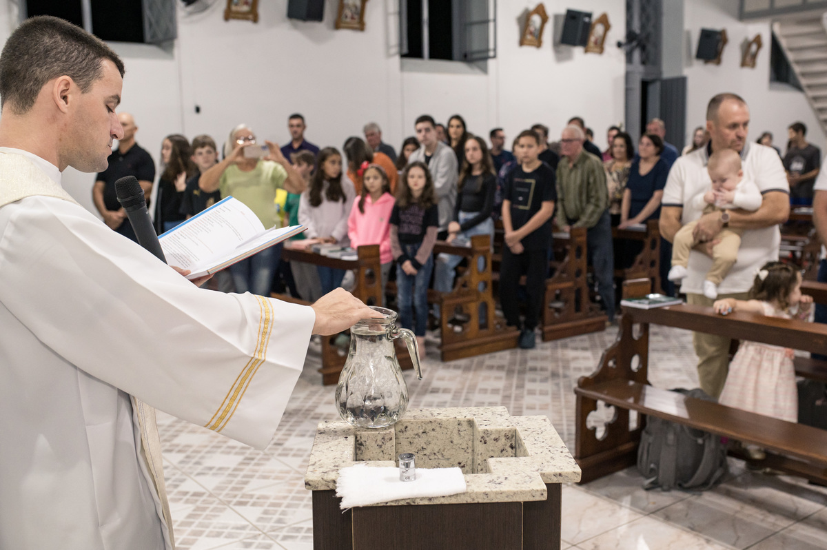 padre abençoando a água do batizado