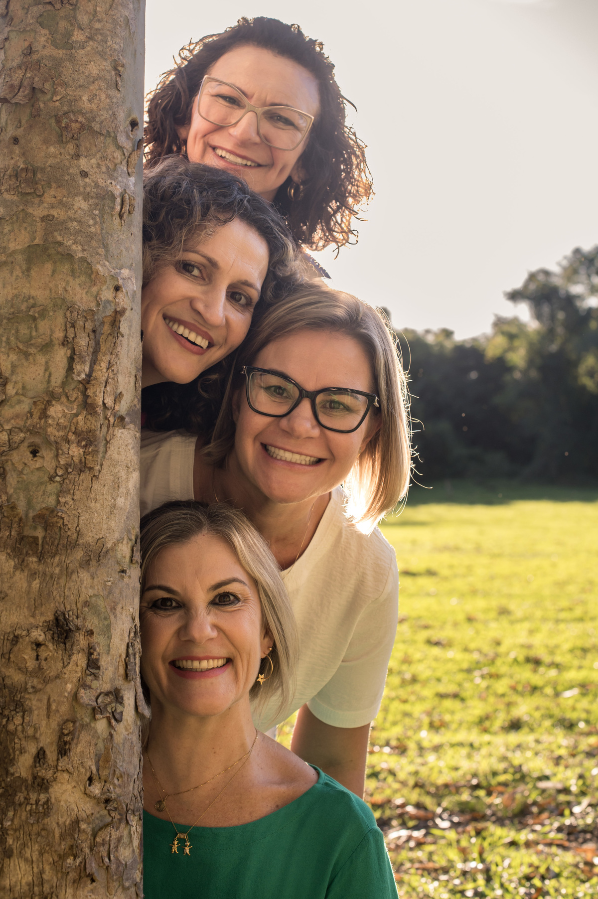 Ensaio externo, amigas atrás da árvore