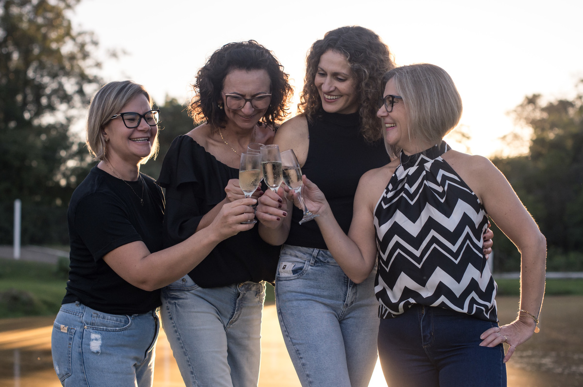 Ensaio externo, amigas brindando a amizade no contra luz