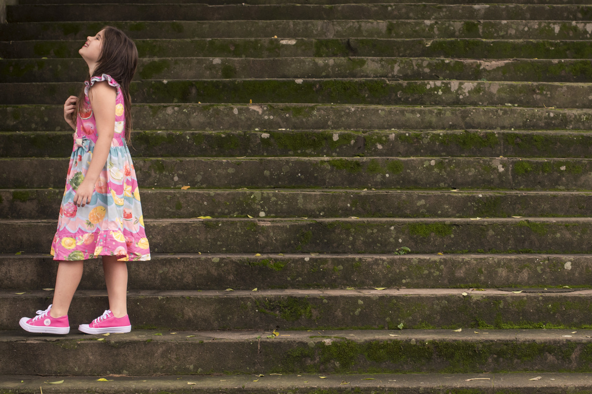 Ensaio externo, menina de vestido colorido na escadaria