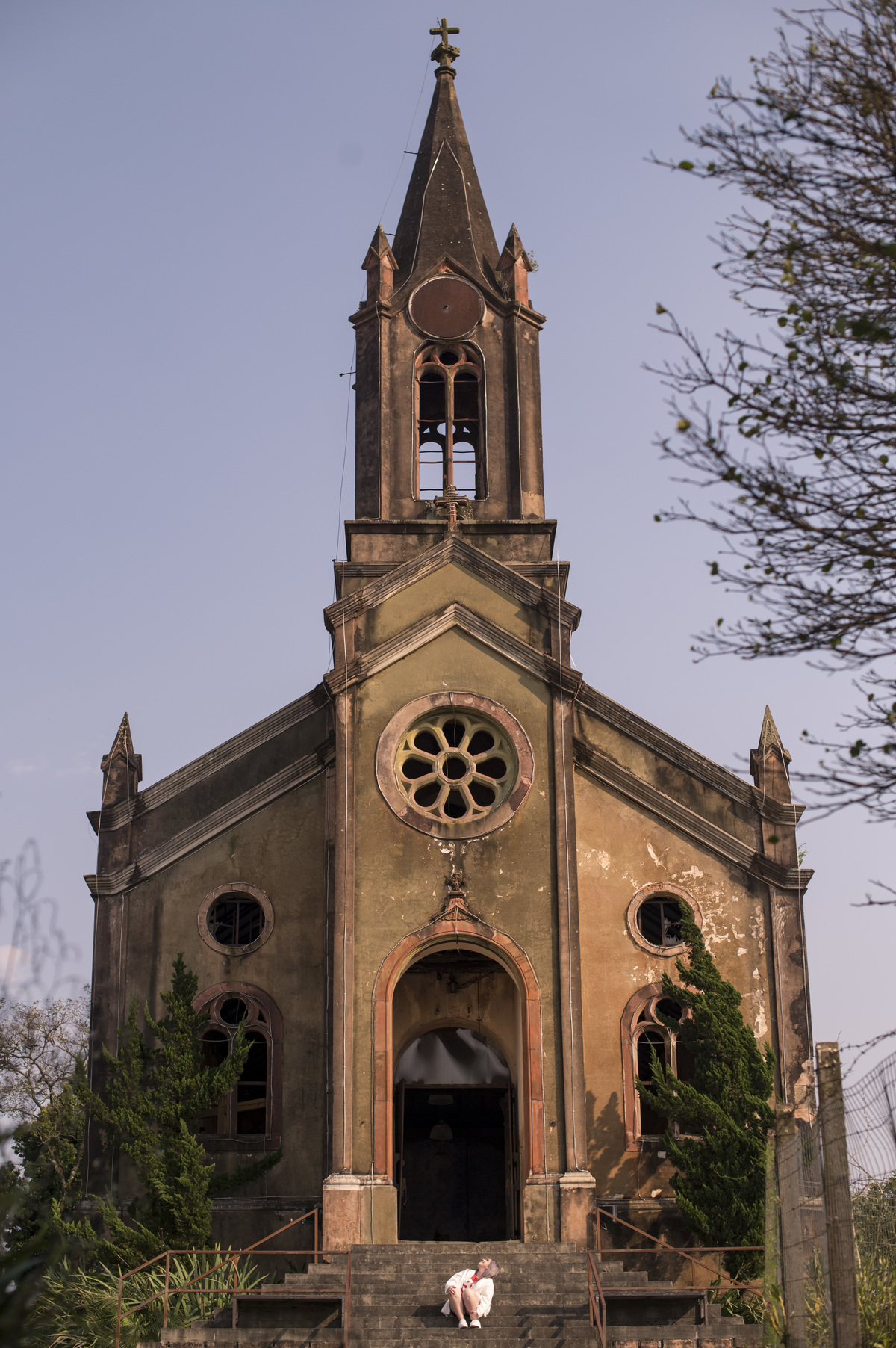 Ensaio feminino em Ivoti, igreja velha, mulher sentada em frente à Igreja