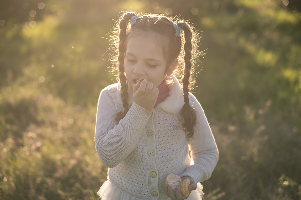 Ensaio externo de família, criança comendo bergamota, flare