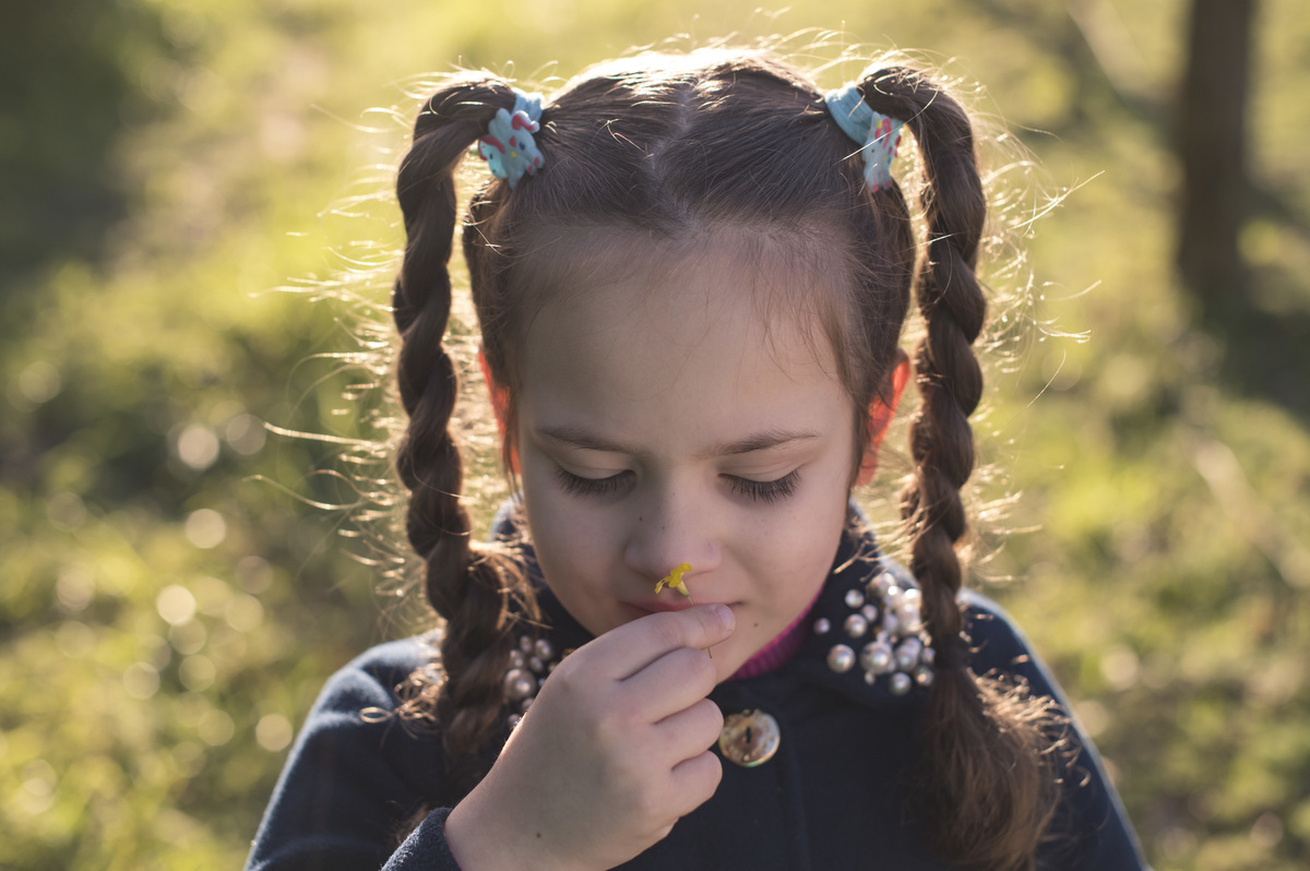 Ensaio externo de família, menina cheirando flor