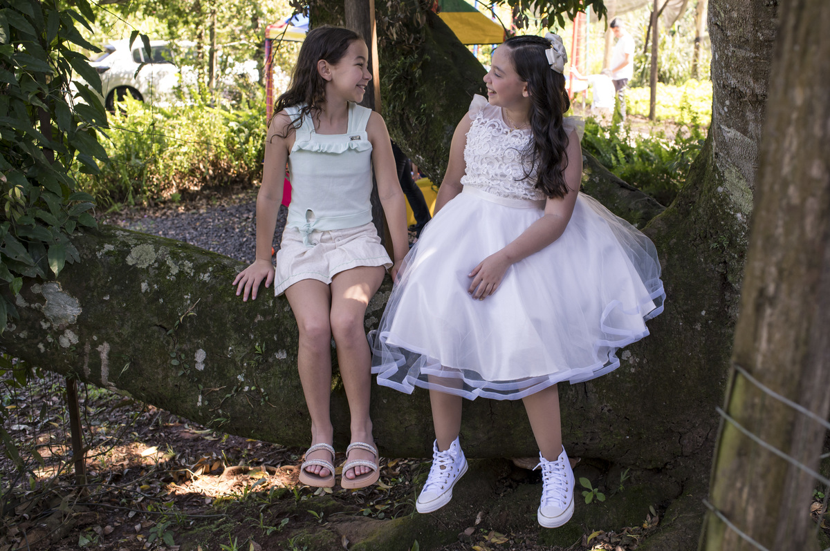 foto de amigas sentadas na árvore em festa de primeira comunhão