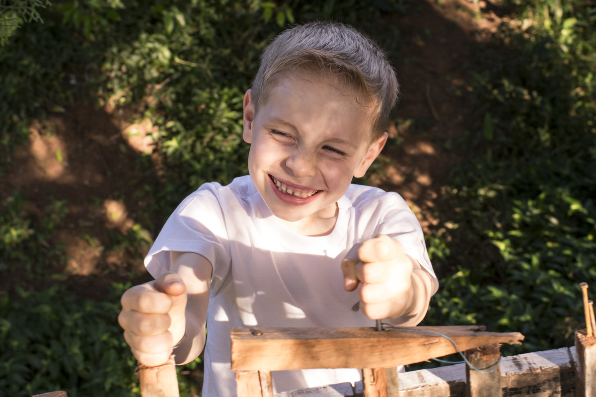 Ensaio externo de família, menino feliz brincando em seu cantinho 