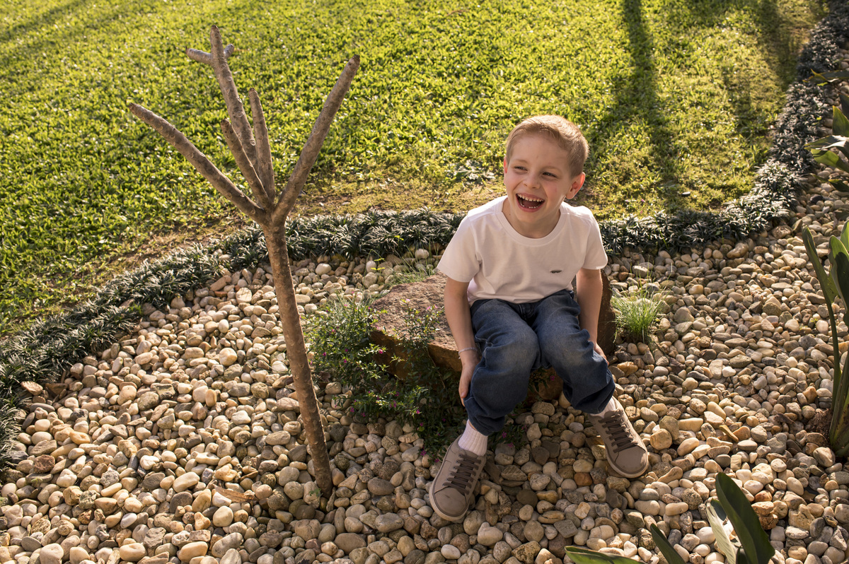Ensaio externo de família, menino feliz no jardim da casa