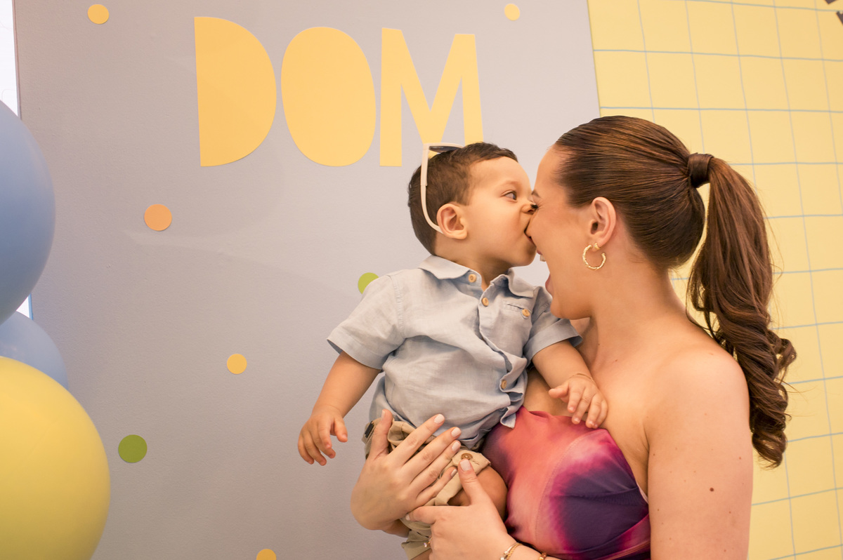 Festa de aniversário infantil, bebê mordendo o nariz da mãe