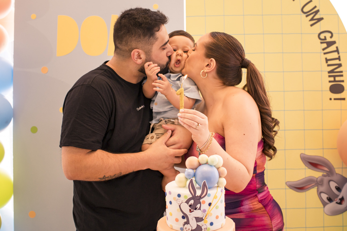 Festa de aniversário infantil, papai e mamãe beijando a bochecha do bebê