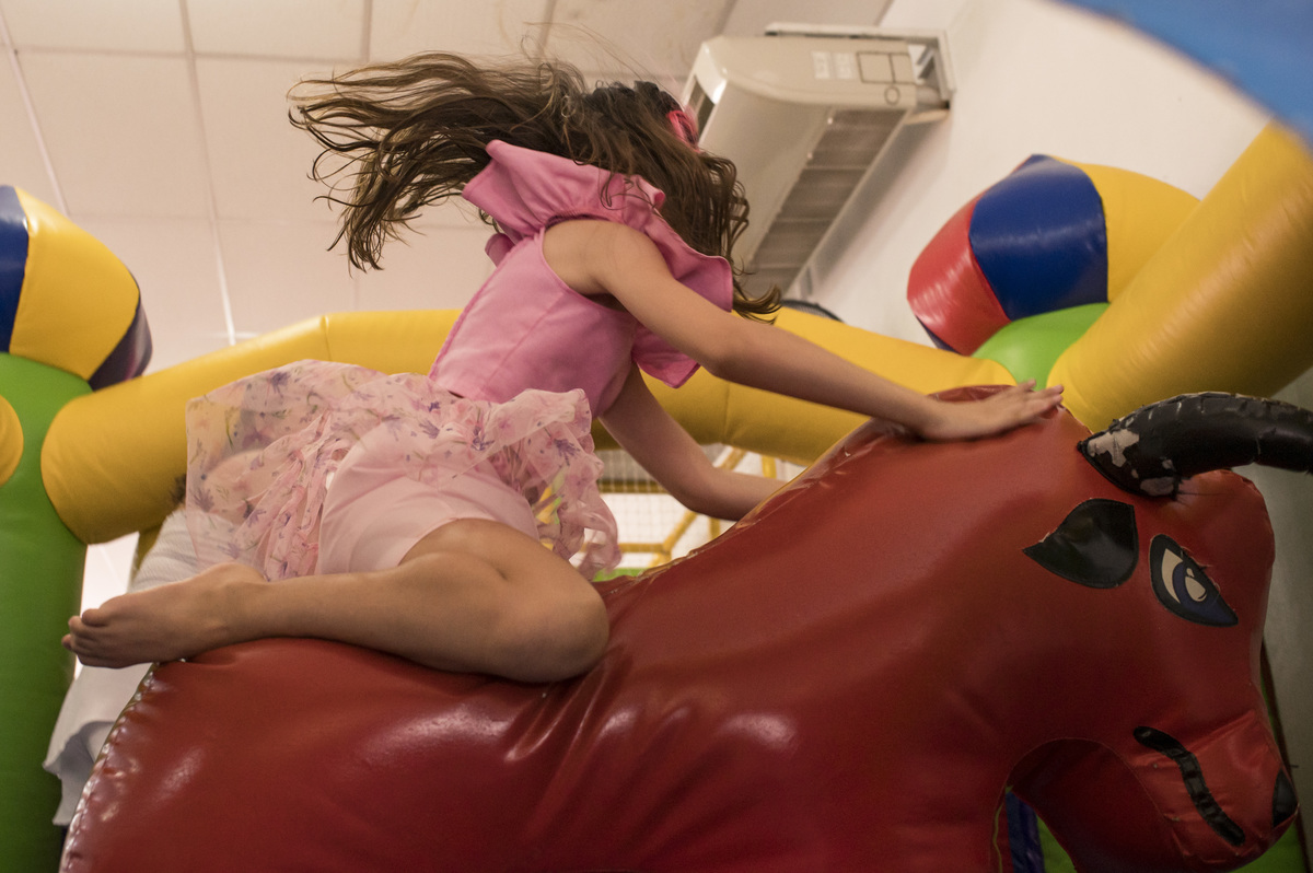 menina brincando no touro em festa infantil