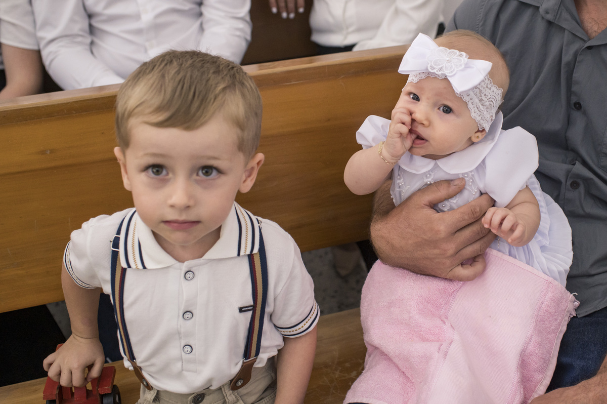 criança com seu irmãozinho no dia do seu batizado
