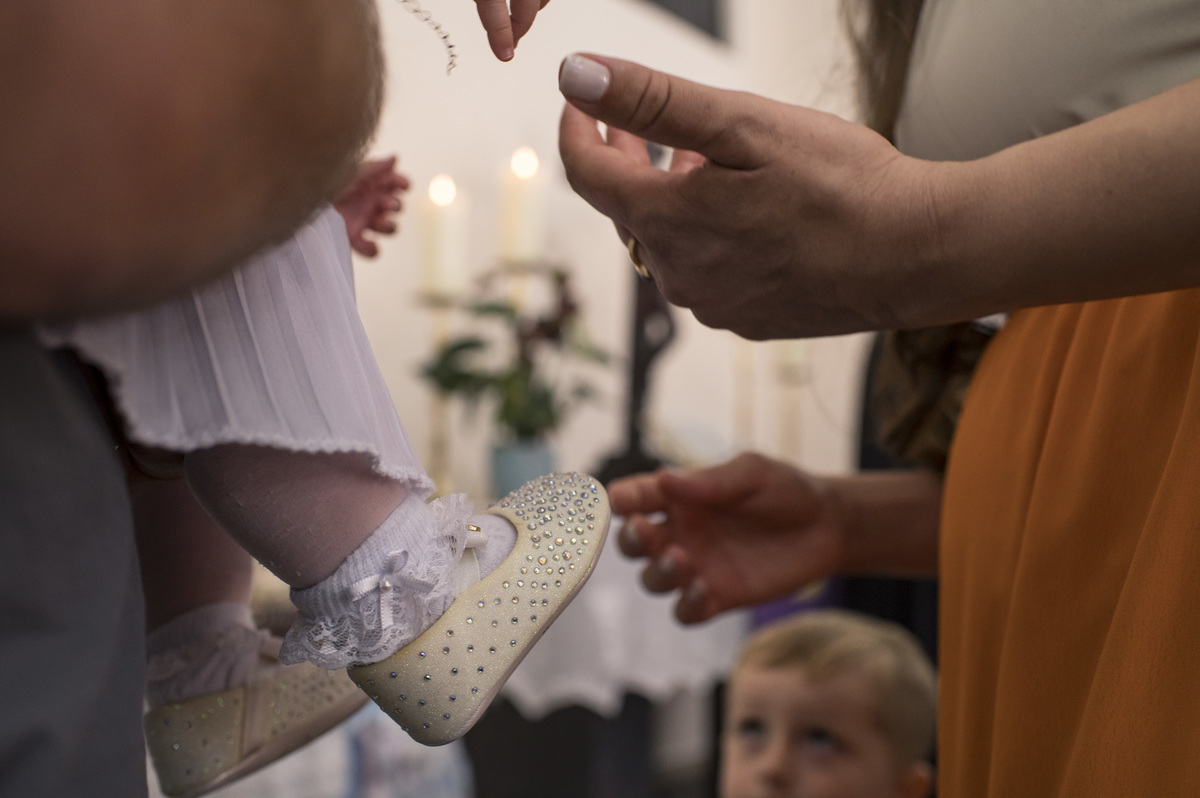 detalhe do sapatinho da criança que vai ser batizada