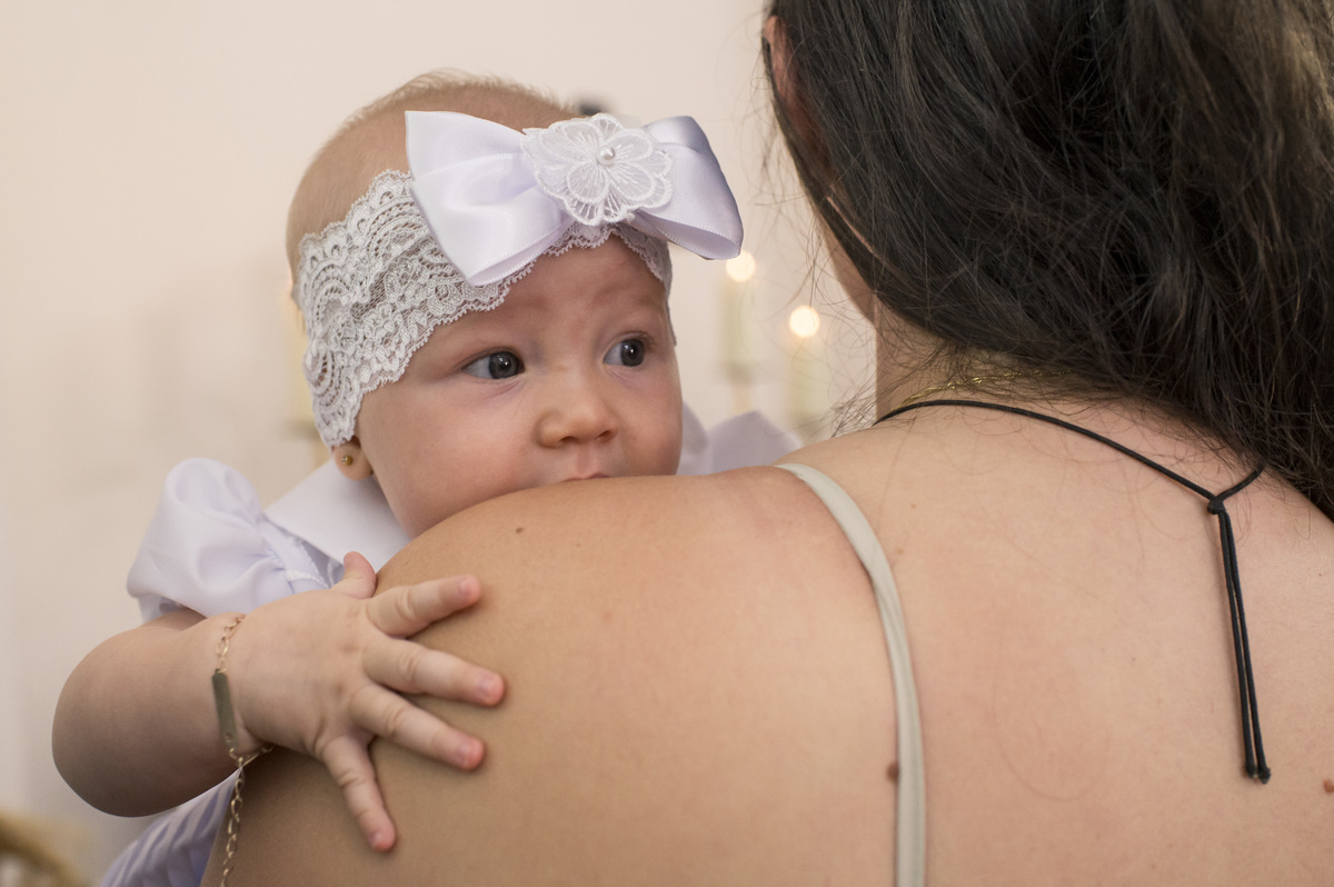 criança que vai ser batizada no colo da mãe