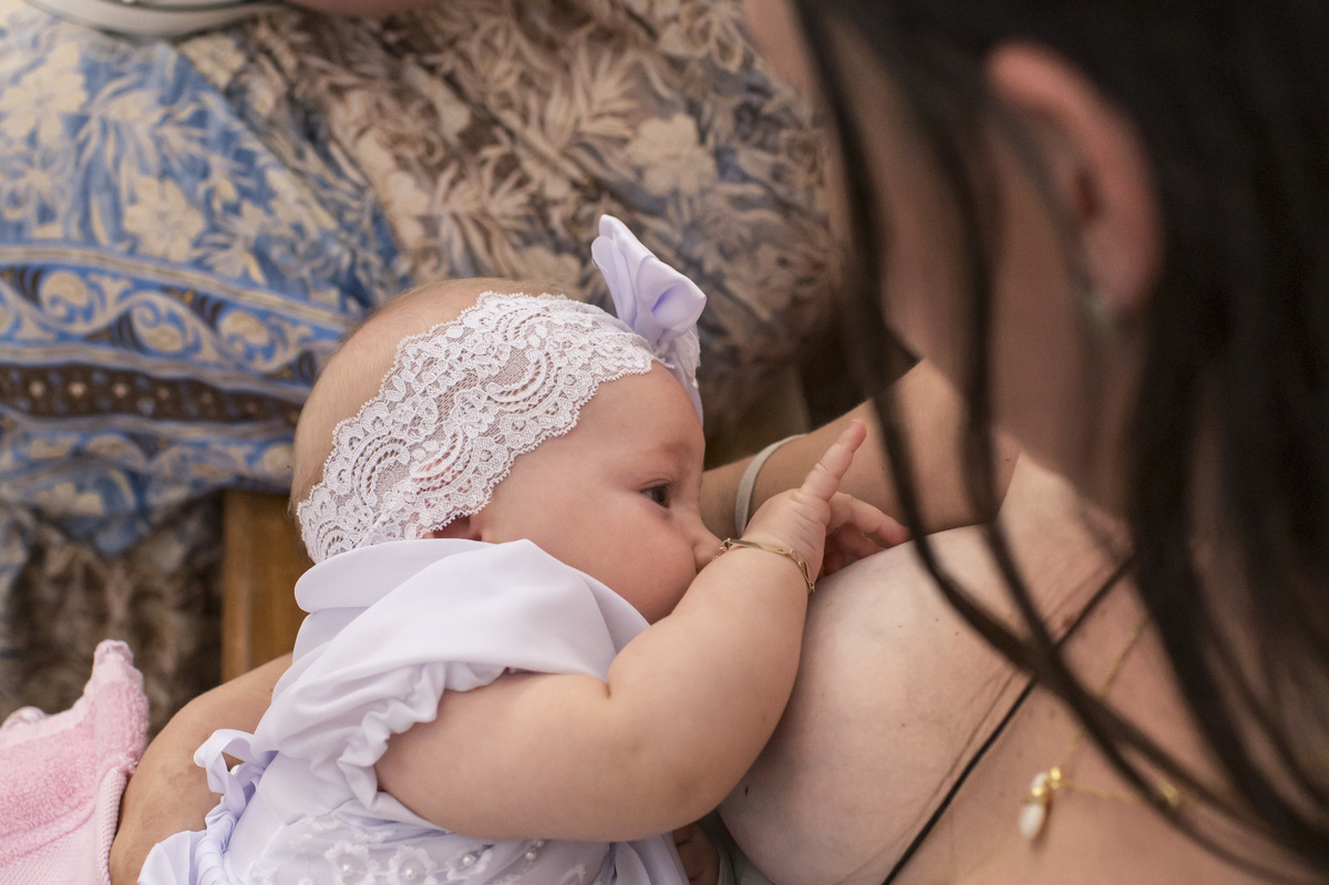 criança mamando após o batizado