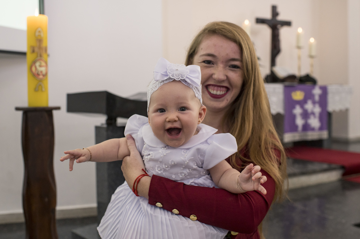 criança dando uma gargalhada no colo da dinda