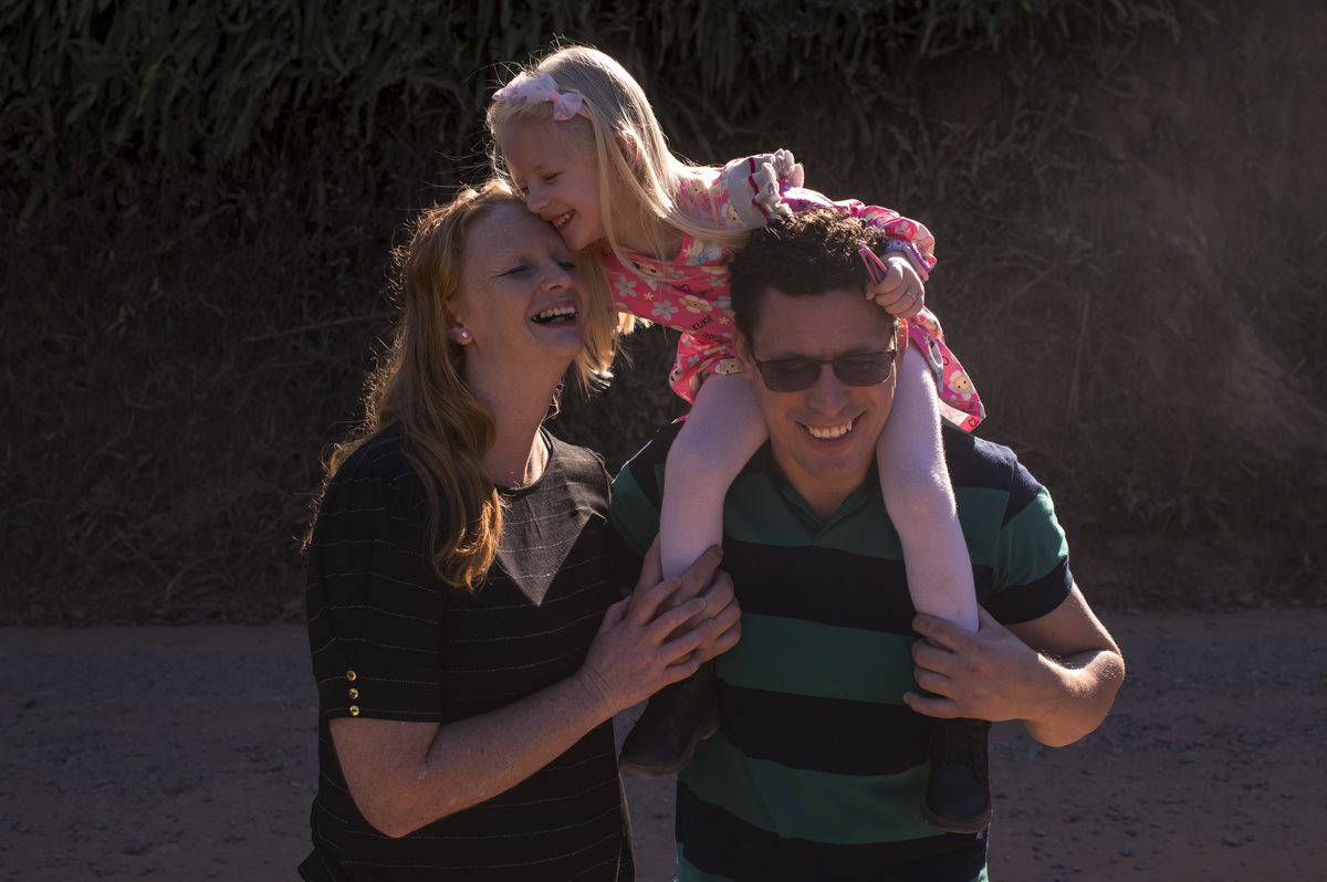 Ensaio externo de família, foto espontânea, criança nos ombros do pai - fotógrafa Claudia Wallauer