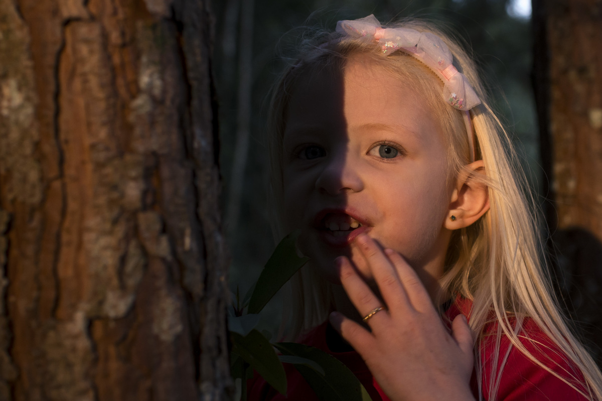 ensaio externo de família, menina bonita com a luz do sol no olho azul
