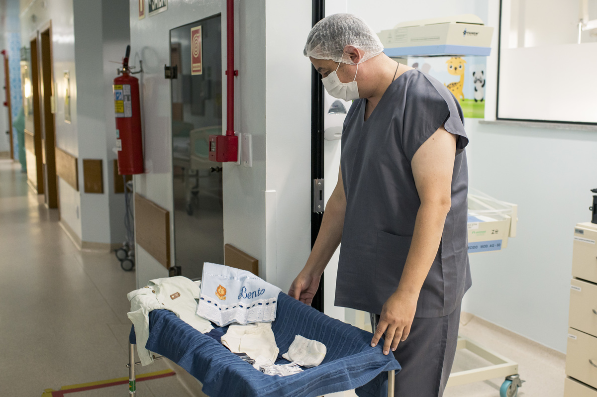 documental de parto, pai olhando roupinhas do bebê