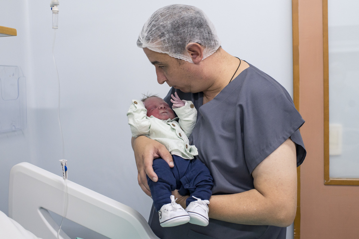 documental de parto, bebê com a primeira roupinha no colo do pai