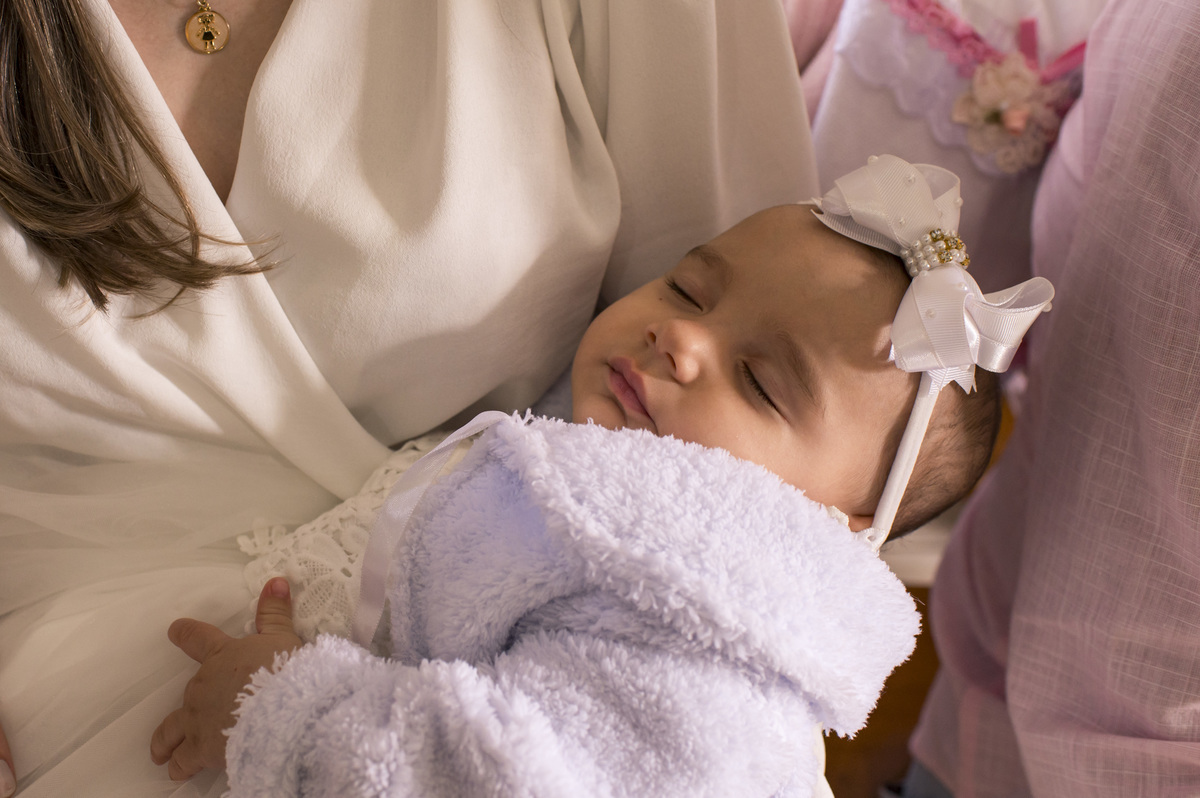 foto de batizado, criança dormindo no colo da mãe fotógrafa Claudia Wallauer