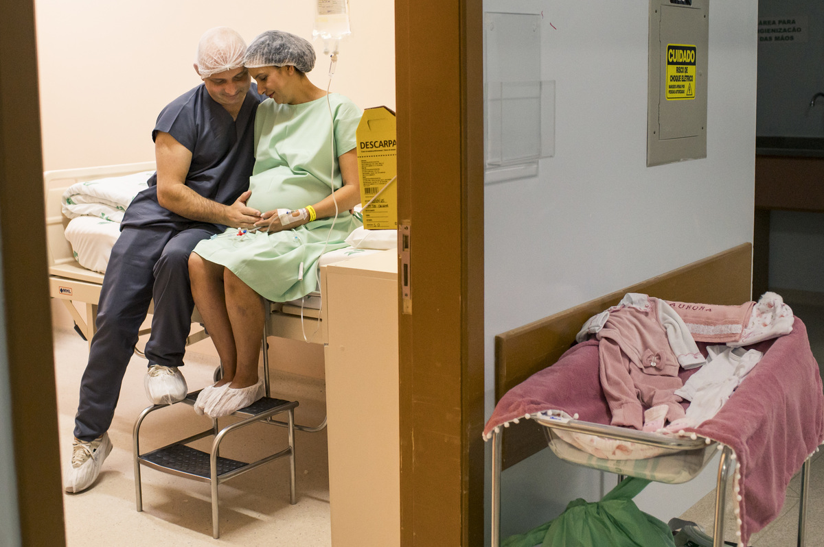 documental de parto, casal trocando carinho enquanto aguarda a hora do parto no hospital unimed vale do caí, fotógrafa Claudia Wallauer