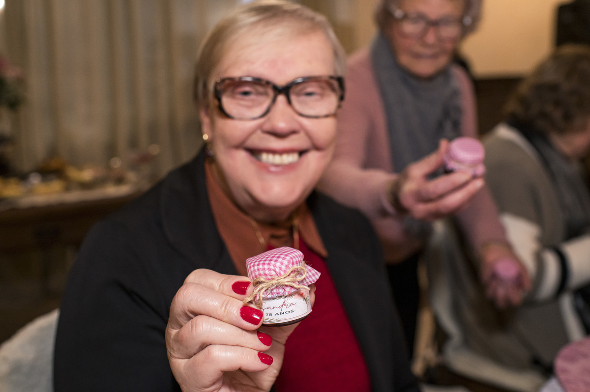 Festa surpresa de aniversário de 75 anos, convidados ganhando lembrancinha