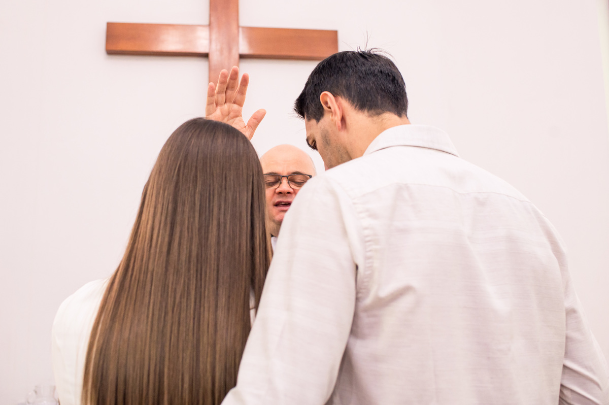 pais do bebê recebendo bênção do pastor na igreja da comunidade de campo do meio