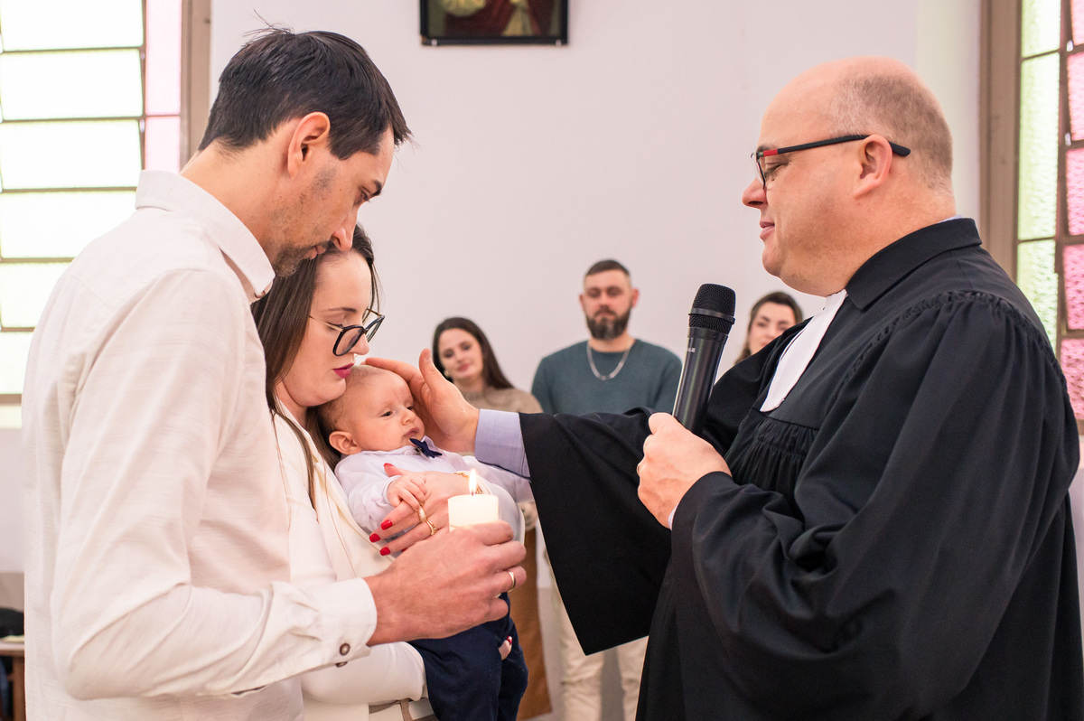pais do bebê recebendo a bênção do pastor na igreja da comunidade evangélica de campo do meio