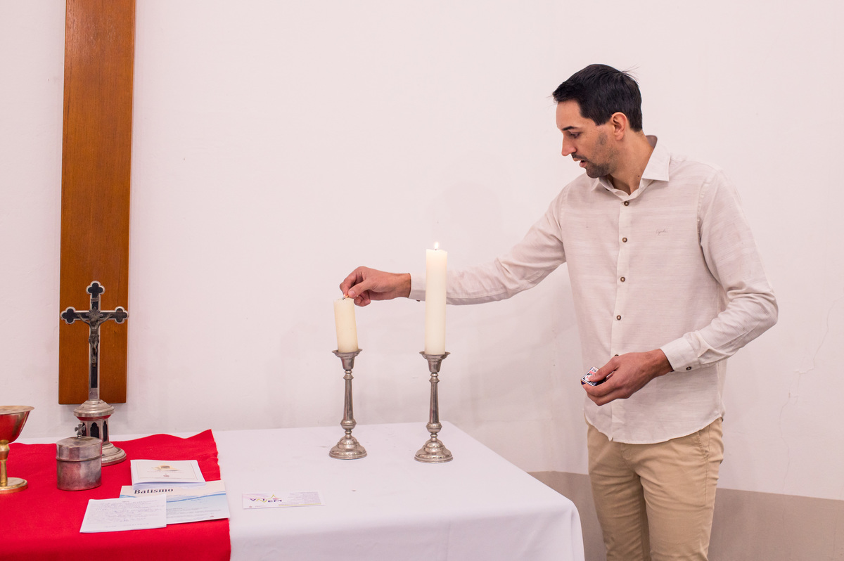 pai acendendo a vela no altar em campo do meio