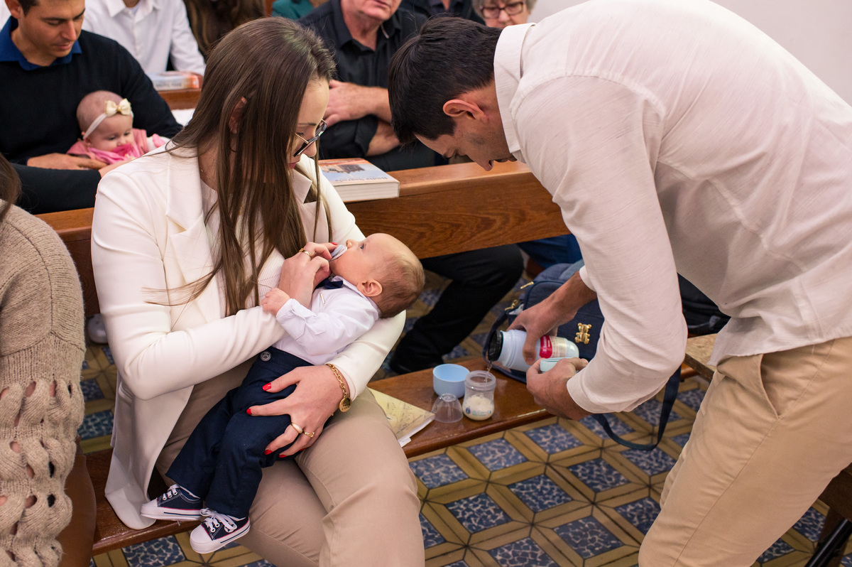 bebê  batizado recebendo mamadeira