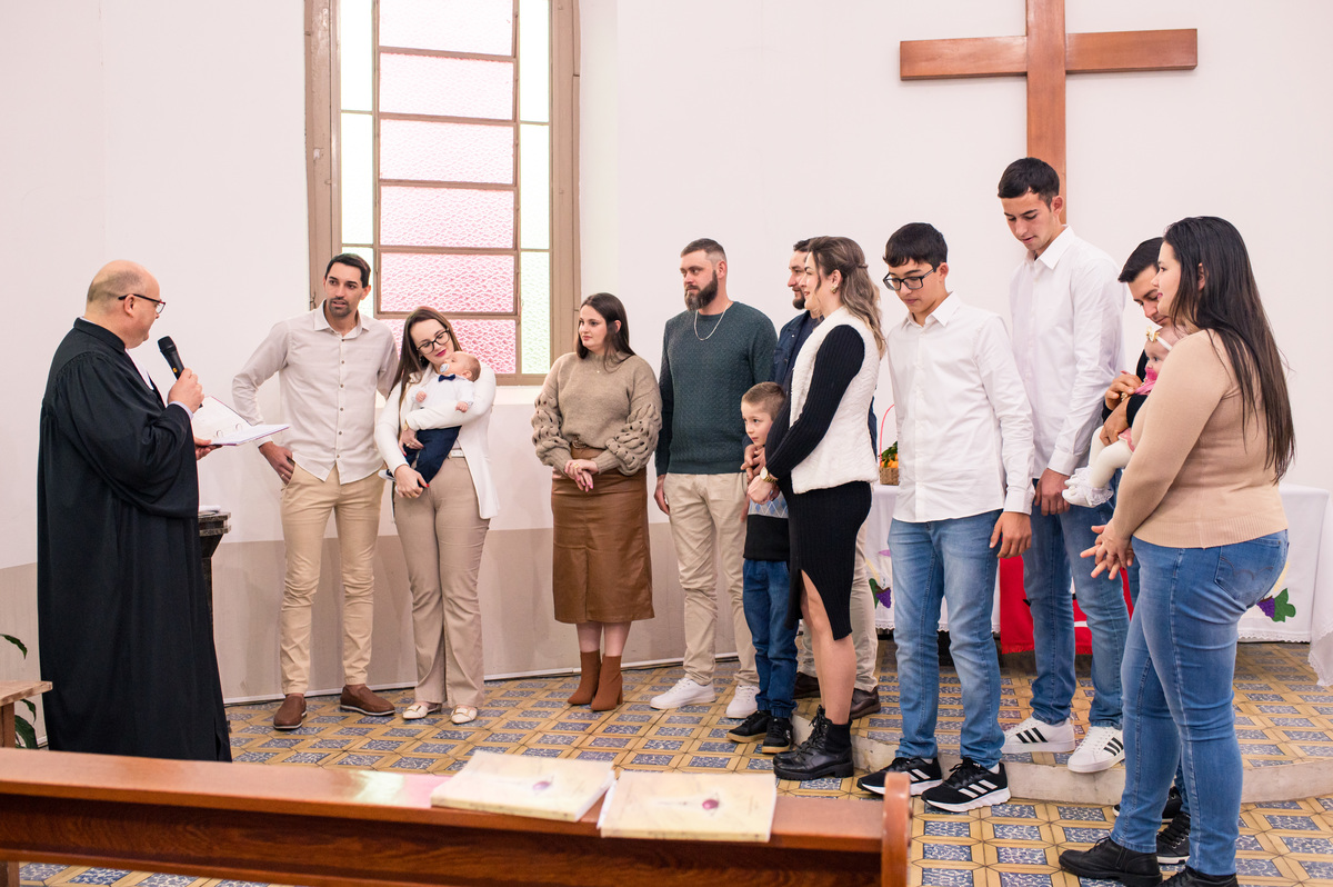 família, padrinhos e madrinhas no altar da igreja de campo do meio na hora do batismo