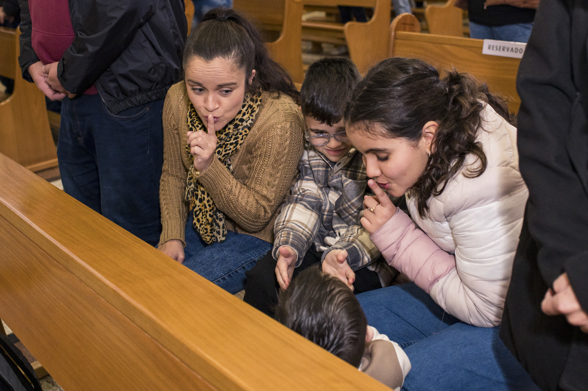 família pedindo para criança ficar quietinha no batizado na Catedral São João Batista em Montenegro RS