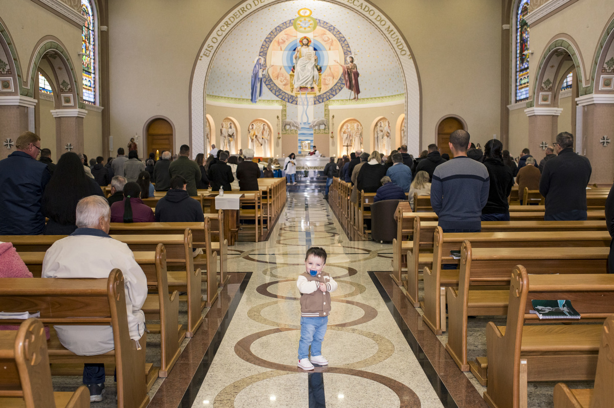 criança no meio do corredor no final da missa no batizado na Catedral São João Batista em Montenegro RS