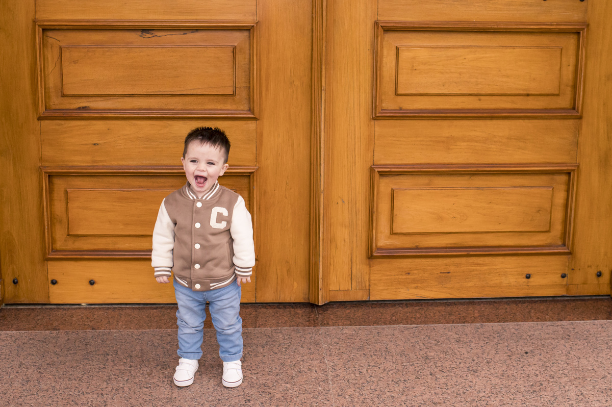criança com cara de sapeca na porta da igreja no batizado na Catedral São João Batista em Montenegro RS