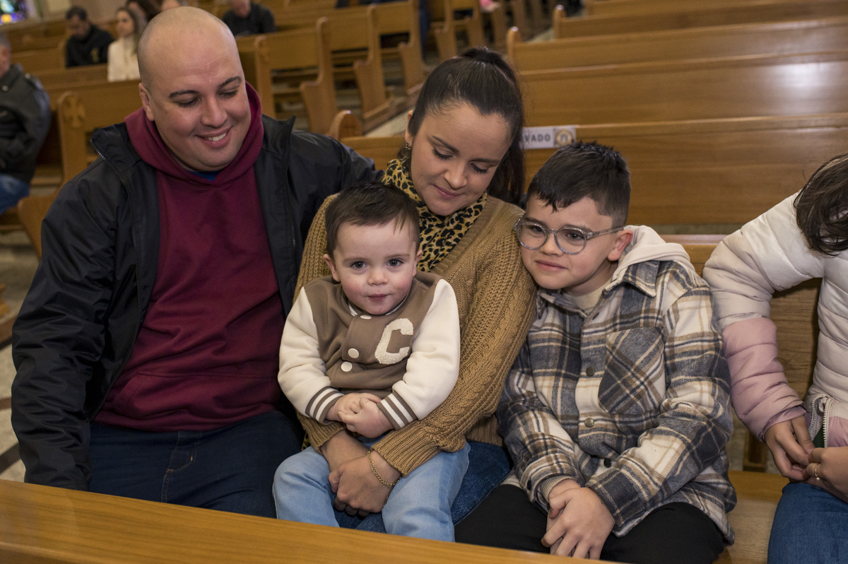 criança com a família no banco no batizado na Catedral São João Batista em Montenegro RS
