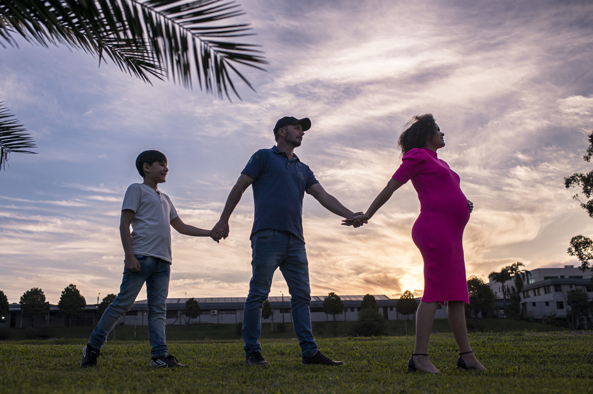 Ensaio fotográfico de gestante externo, família com o por do sol ao fundo