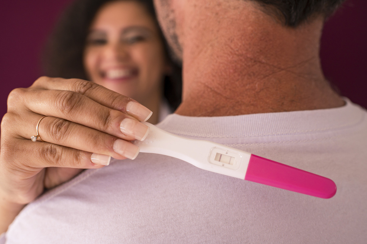 Ensaio fotográfico de gestante em estúdio, fotografia do resultado do exame de gravidez