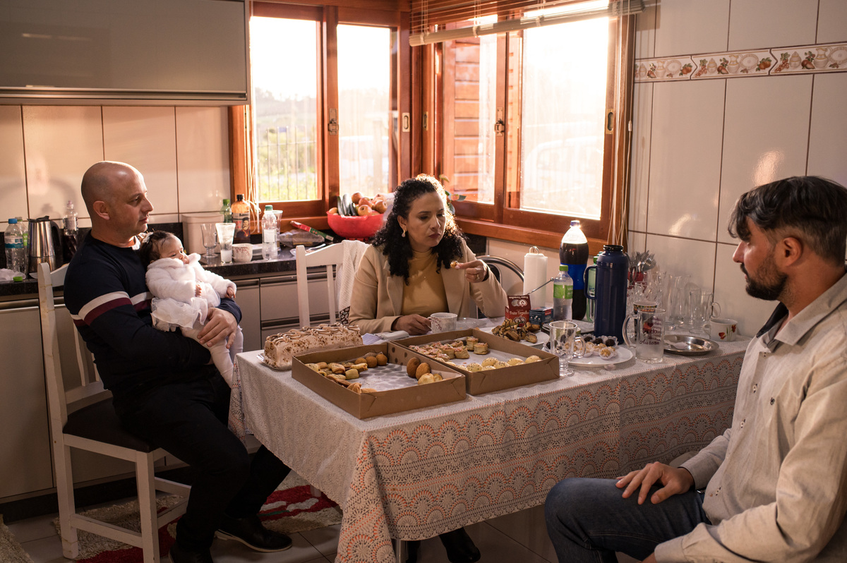 Batizado em São José do Sul, família tomando café com a luz do sol entrando pela janela