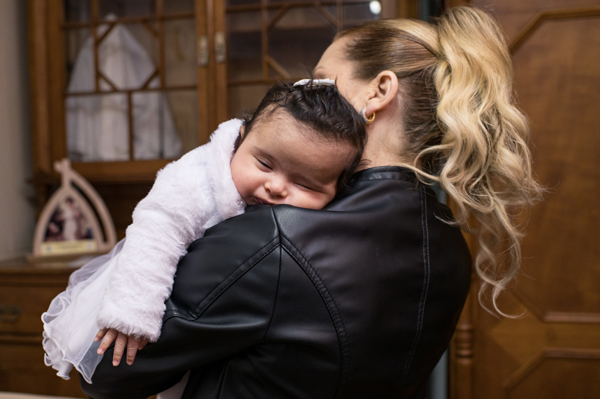 Batizado em São José do Sul, Capela São Francisco de Salles, bebê dormindo no colo da madrinha na sacristia