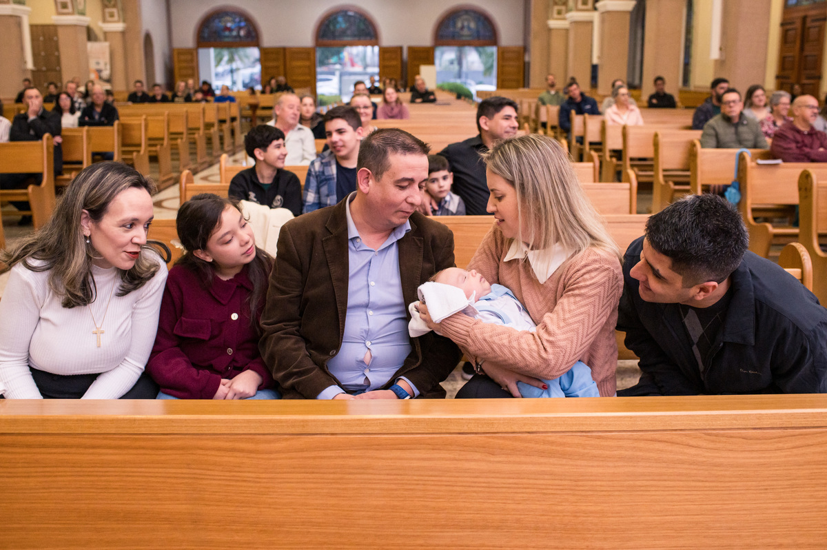 Batismo na Catedral São João Batista em Montenegro, pais e padrinhos admirando o bebê após o batismo