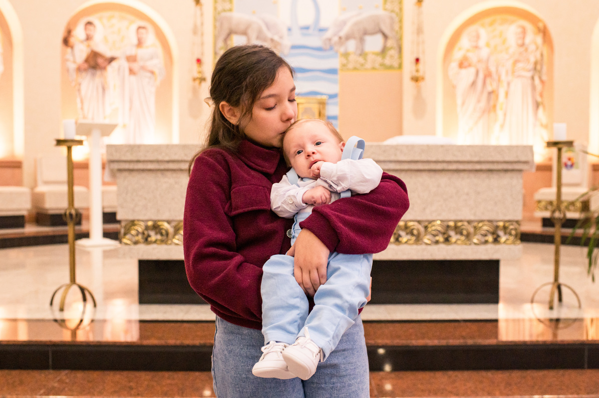 Batismo na Catedral São João Batista em Montenegro, foto do bebê no colo da irmã