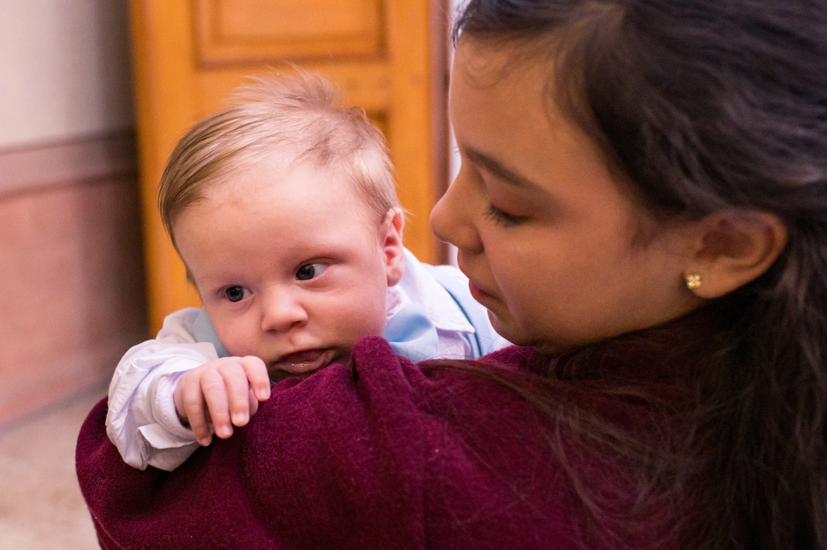 Batismo na Catedral São João Batista em Montenegro, bebê ganhando colinho da irmã