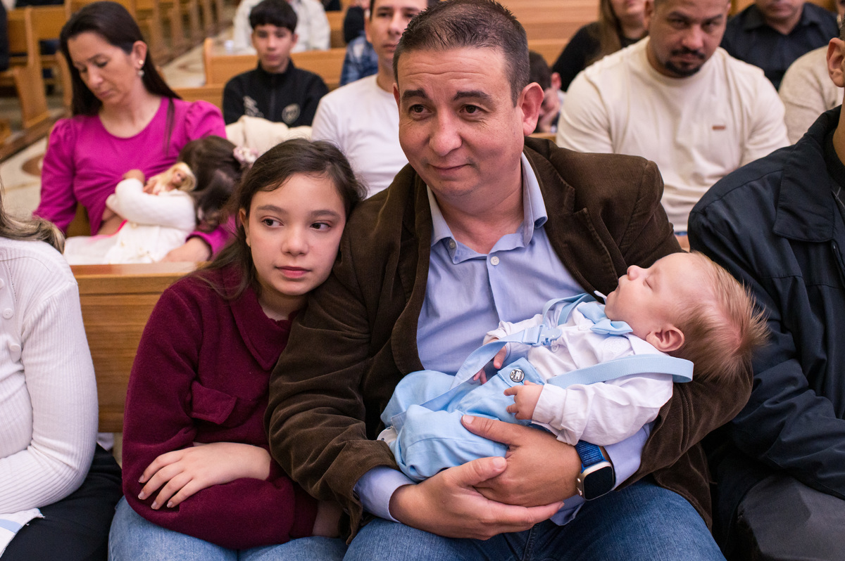 Batismo na Catedral São João Batista em Montenegro, bebê dormindo no colo do pai 