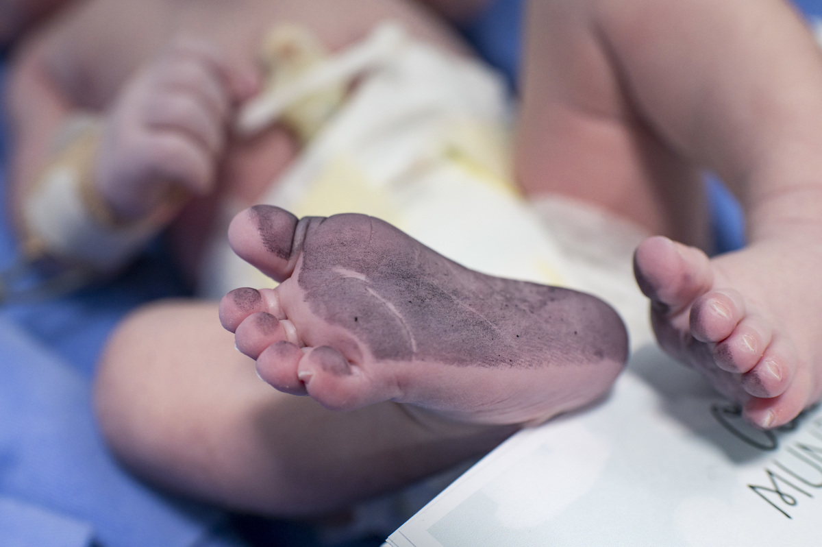 Documental de parto/cesária no hospital Unimed Vale do Caí, pé do bebê com a tinta do carimbo